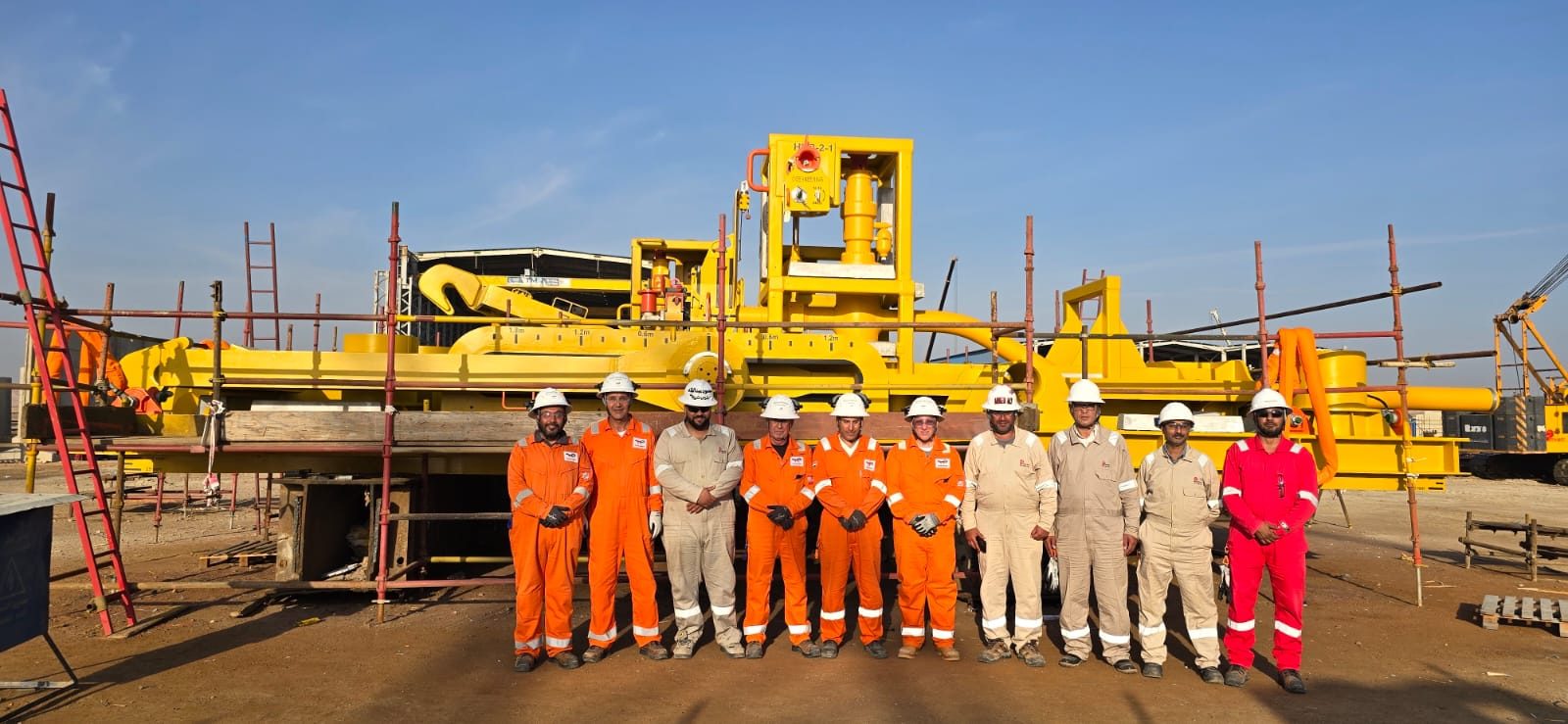 Coating inspection team standing in front of a large yellow subsea structure at the Mozambique LNG offshore project