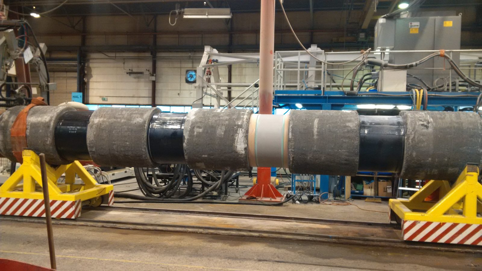 Concrete-weight-coated pipe joints with field joint coating infill on a test rig