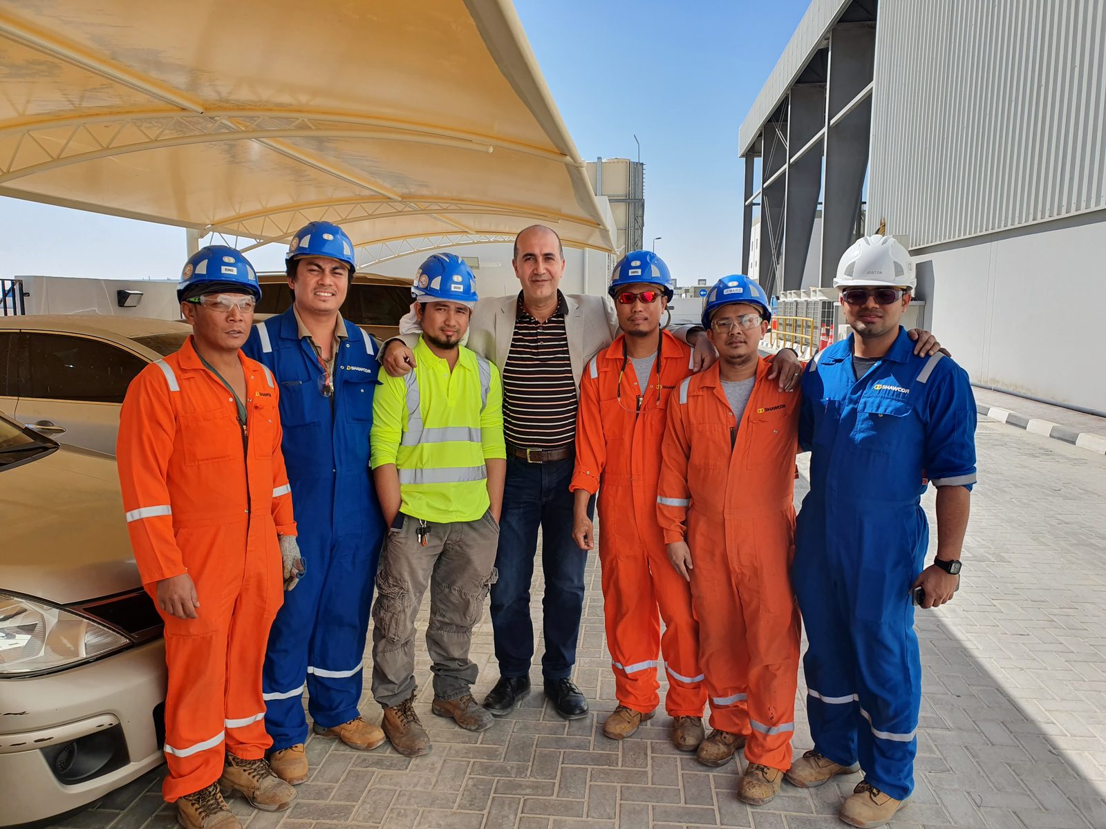 Ehab Abutahoun with six members of his Shawcor technical team in coveralls and hard hats